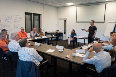 Deelnemers luisteren aandachtig naar een docent tijdens de cursus 'Conciërge in het onderwijs'