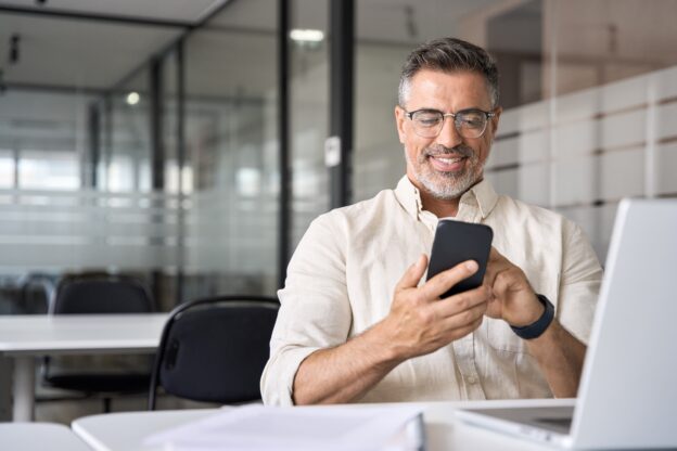 Man aan de telefoon in een schoolomgeving