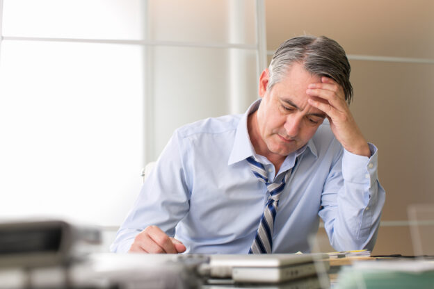 Man die een planning opstelt met notities en notities op een bureau voor zich