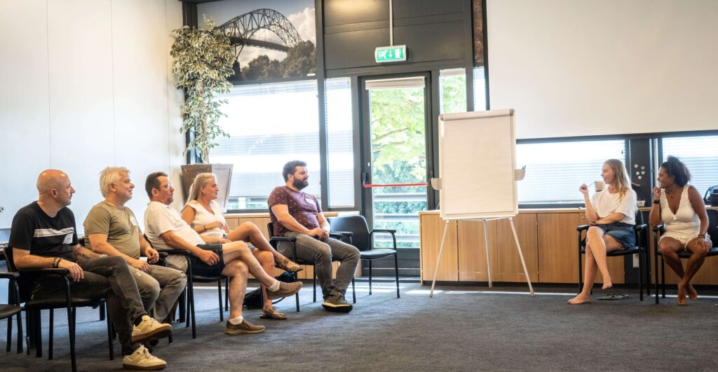 Groep mensen in kringgesprek in vergaderruimte