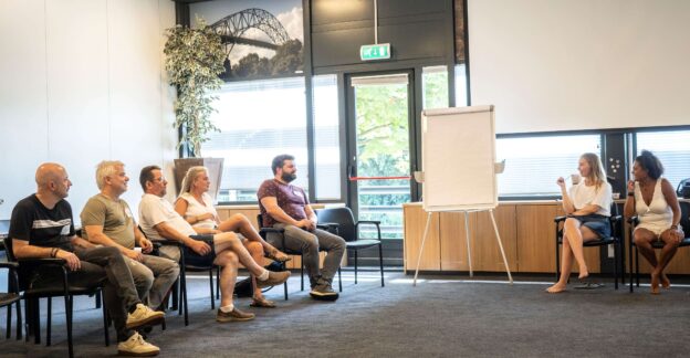 Groep mensen in kringgesprek in vergaderruimte